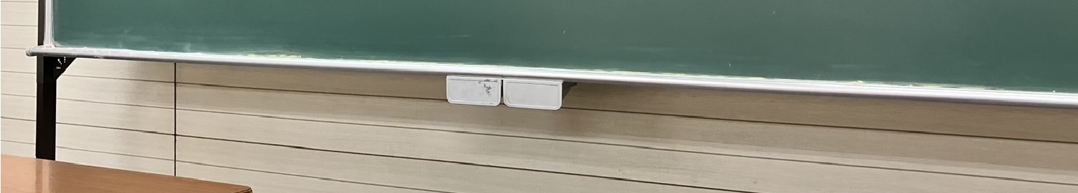 教室の黒板と机の風景。落ち着いた学びの空間を演出しています。