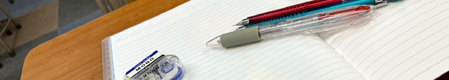 体験授業で使用するノートと筆記具が置かれた教室の机